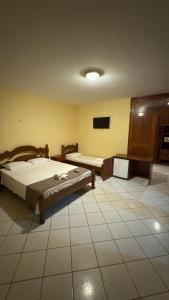 a bedroom with two beds and a tiled floor at Hotel & Pousada Italia Beach - Porto Das Dunas in Aquiraz +35 photos