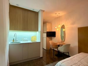 a bedroom with a bed and a kitchen with a table at Pure Sense in Beʼer Ora