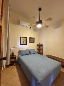 a bedroom with a blue bed and a ceiling fan at Seville Suite in San Juan del Sur +43 photos