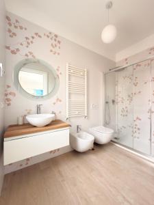 a bathroom with two sinks and a shower at Riganvì Affittacamere Sestu in Sestu