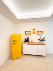 a yellow refrigerator in a kitchen with a counter at Riganvì Affittacamere Sestu in Sestu +49 photos