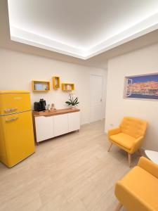 a room with a yellow cabinet and a yellow chair at Riganvì Affittacamere Sestu in Sestu