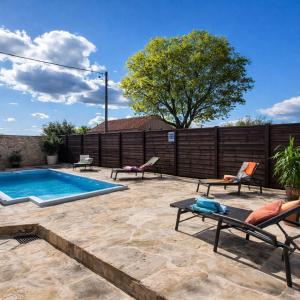 a patio with chairs and a swimming pool at Holiday home Dida Jere in Benkovac
