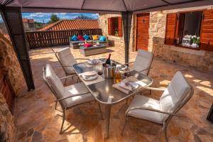 a patio with a table and chairs and a couch at Holiday home Dida Jere in Benkovac