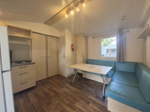 a living room with a blue couch and a table at Mobil Home 3Ch - 6Pers 15min Europa PARK in Boofzheim