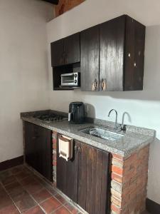 a kitchen with a counter with a sink and a microwave at Casa casco urbano in San Gil