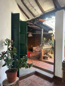 a patio with green doors and potted plants at Casa casco urbano in San Gil