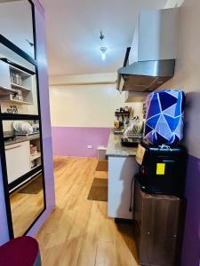 a kitchen with purple walls and a counter top at Dysha's Home in Davao City