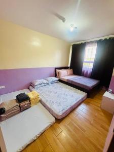 a room with two beds and a couch at Dysha's Home in Davao City +15 photos