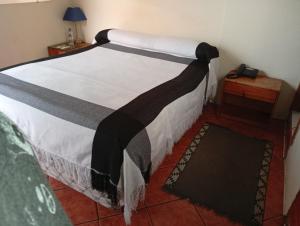 a bedroom with a bed with a black and white blanket at Hospedaje Las Garzas in Ibarra +1 photo