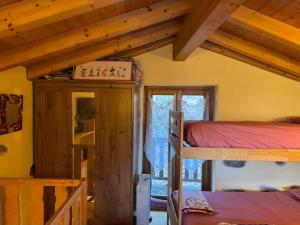 a bedroom with two bunk beds and a window at La Casetta di Cri Morbegno in Morbegno