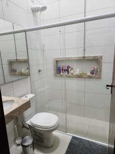 a white bathroom with a toilet and a shower at Casa Completa e Funcional in Sinop +11 photos