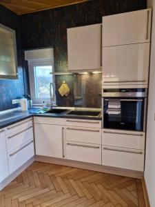 a kitchen with white cabinets and a stove top oven at Mary´s Ferienwohnung in Kevelaer