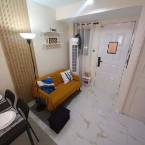 a living room with a yellow couch and a door at Tanza, Cavite Transcient House near SM in Tanza