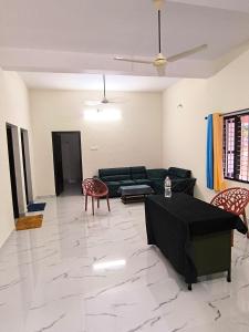 a living room with a black couch and chairs at Star Varkala Homestay in Varkala
