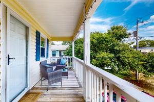 a front porch with a chair and a table at Salty Tails in Kill Devil Hills