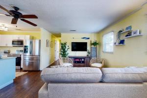 a living room with a couch and a kitchen at Salty Tails in Kill Devil Hills