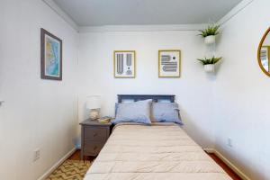 a small bedroom with a bed and a nightstand with a bed sidx sidx sidx at Salty Tails in Kill Devil Hills