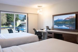 a hotel room with two beds and a flat screen tv at Inn The Mountains, an Ascend Collection Hotel in Hope