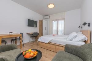a hotel room with a bed and a table with a bowl of fruit at Apartments Blue Adriatic View in Jesenice