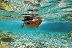 a person swimming in the water with goggles on at Apartment Heritage Stonehouse in Ugljan