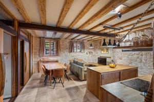 a kitchen with wooden ceilings and a table and chairs at Apartment Heritage Stonehouse in Ugljan +15 photos