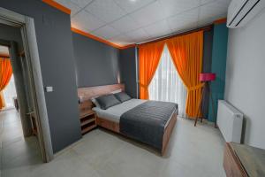 a bedroom with a bed in a room with orange curtains at City Life in İskenderun