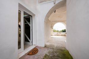 an entrance to a white room with an archway at Respiro di Chiaia in Procida