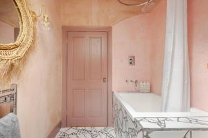 a bathroom with a tub and a sink and a mirror at The Wood Wing Suite at Bellspool in Peebles