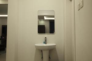 a bathroom with a white sink and a mirror at شقق أونيسن للشقق المخدومة Onsen Serviced Apartments in Buraydah +19 photos