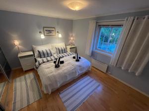 a bedroom with a white bed and a window at Spacious villa with heated pool and stunning view in Tokenes