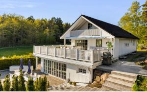 a large white house with a deck at Spacious villa with heated pool and stunning view in Tokenes