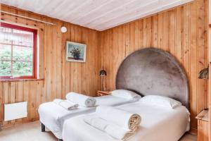 two beds in a room with wooden walls at Torsby Camping in Torsby