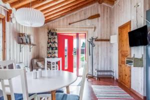 a dining room with a white table and a red door at Torsby Camping in Torsby