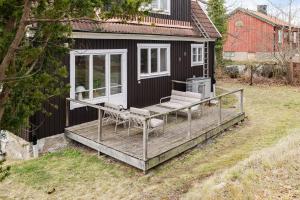 a black house with a deck and chairs on it at Chic 2-Bedroom apartment on Lidingö in Lidingö