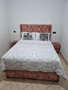 a bedroom with a large bed with a brown headboard at Appartement villa spacieuse 200m2 terrasse prive grand jardin et piscine in Meknès +17 photos