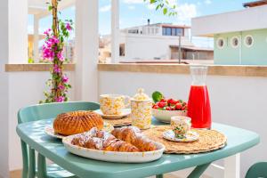 a table with croissants and fruit on a balcony at La Casa al mare Torre San Giovanni in Torre San Giovanni Ugento +20 photos