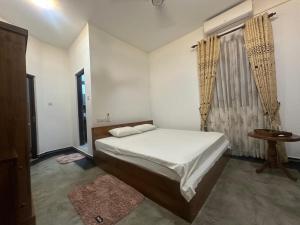 a small bedroom with a bed and a window at Lanka Villa Beruwala in Beruwala +5 photos