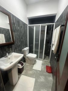 a bathroom with a white toilet and a sink at Lanka Villa Beruwala in Beruwala