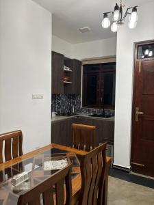 a kitchen with a glass table and wooden chairs at Lanka Villa Beruwala in Beruwala