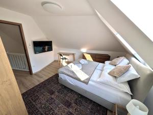 a bedroom with a bed with white sheets and pillows at Monbuhim Four in Veszprém