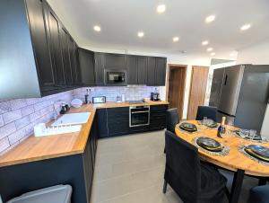 a kitchen with black cabinets and a wooden counter top at Monbuhim Four in Veszprém
