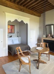 a bedroom with a bed and a table and chairs at Demeure Bouquet in Ambierle