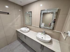 a bathroom with two sinks and a mirror at Reddy Homes in Lautoka