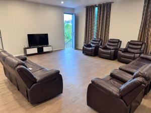 a living room with leather furniture and a flat screen tv at Reddy Homes in Lautoka