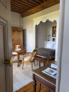 a bedroom with a bed and a table and chairs at Demeure Bouquet in Ambierle