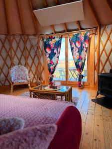 a room with a bed and a table and a window at Glamping Niebiańska Osada Jurty Dolnośląskie in Polanica-Zdrój