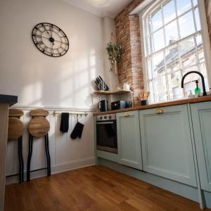 a kitchen with a clock on the wall at The Counting House in Alnwick
