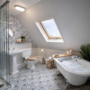 a bathroom with a tub and a toilet and a sink at The Counting House in Alnwick