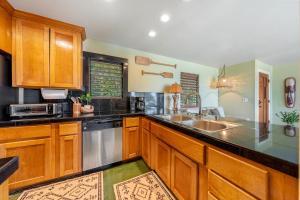 a kitchen with wooden cabinets and a sink at Hale Kepuhi in Hanalei